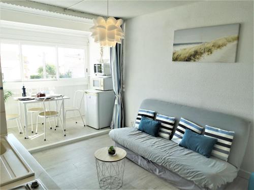 ein Wohnzimmer mit einem Sofa und einem Tisch in der Unterkunft Apartment Les Balcons de la Méditerranée-15 by Interhome in Narbonne-Plage