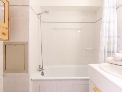une salle de bain blanche avec une baignoire et un lavabo dans l'établissement Studio Le Bollin - Val Claret-3 by Interhome, à Tignes