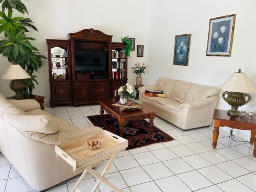 sala de estar con 2 sofás y TV en Villa Hibiscus by Interhome, en Bonita Springs