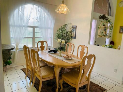 comedor con mesa de madera y sillas en Villa Hibiscus by Interhome, en Bonita Springs