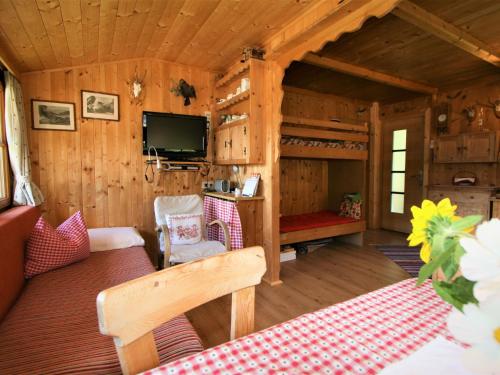 uma sala de estar de um chalé de madeira com uma cama em Chalet Chalet Antritt by Interhome em Schmirn