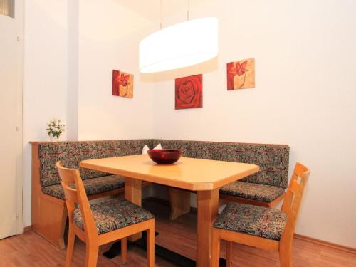 een eettafel en stoelen met een kom erop bij Apartment Am Birkenhain-17 by Interhome in Seefeld in Tirol