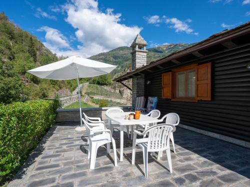 a patio with a table and chairs and an umbrella at Chalet Sanitate by Interhome in Leverogne Rochefort