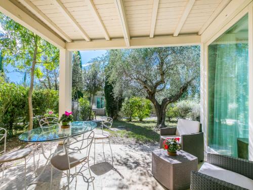 CollemezzanoにあるHoliday Home Biovillage-1 by Interhomeの屋外パティオ(ガラスのテーブル、椅子付)
