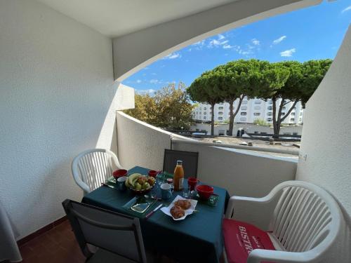 a table with a plate of food on a balcony at Apartment Le Viking by Interhome in La Grande Motte