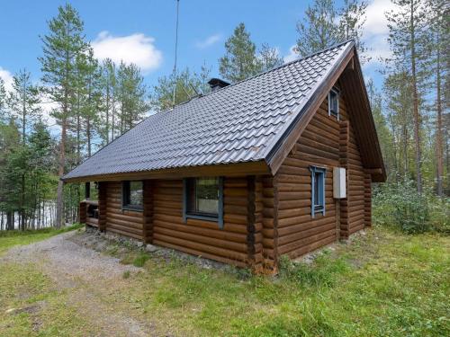 a log cabin with a roof on a field at Holiday Home Iltatähti by Interhome in Kirpistö