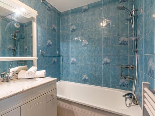 La salle de bains est pourvue de carrelage bleu, d'une baignoire et d'un lavabo. dans l'établissement Apartment Les Tommeuses - Val Claret-9 by Interhome, à Tignes