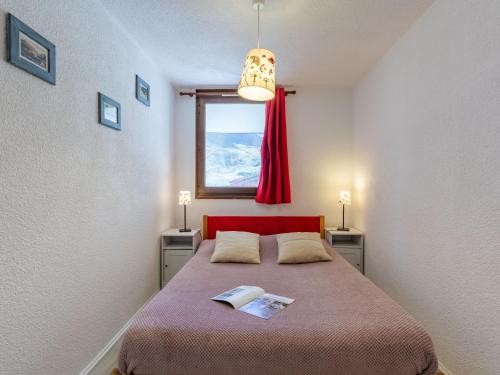 una camera con letto con testiera rossa e finestra di Apartment Les Tommeuses - Val Claret-9 by Interhome a Tignes