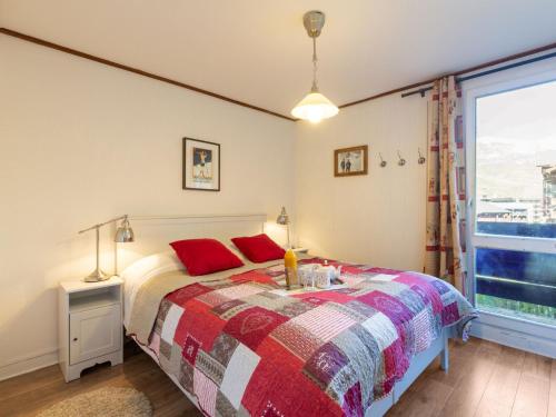 a bedroom with a bed with red pillows and a window at Apartment Le Pramecou - Val Claret-11 by Interhome in Tignes