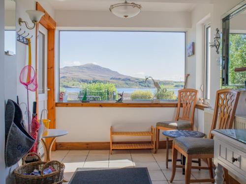 a room with a large window with chairs and a table at Holiday Home Viewfield by Interhome in Portree