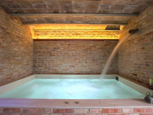 Apartment Borgo della Limonaia-1 by Interhome في بييفي أنييفولي: حوض استحمام مع نافورة مياه في جدار من الطوب