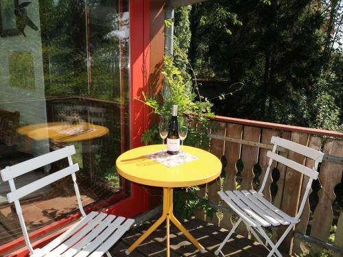 a yellow table and two chairs on a patio at Holiday Home Clobes in Unshausen