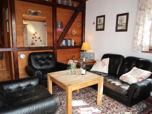sala de estar con sofás de cuero negro y mesa en Holiday Home Clobes by Interhome, en Unshausen