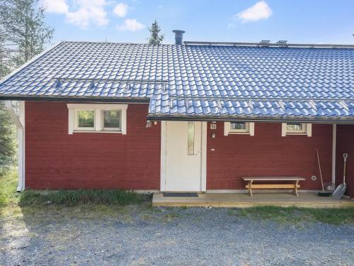 een rood huis met een bank ervoor bij Holiday Home Rintelä 5a by Interhome in Ruka