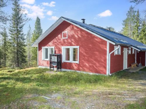 een rood huis in het midden van een veld bij Holiday Home Rintelä 5a by Interhome in Ruka