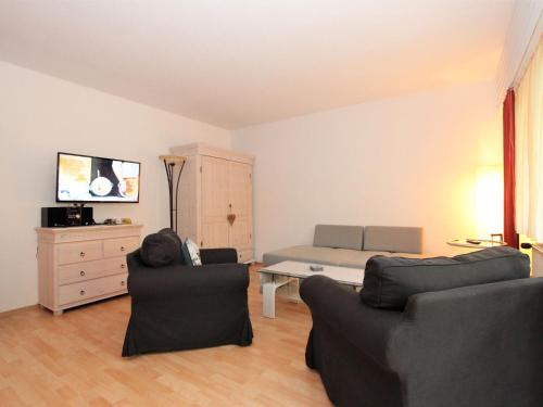 ein Wohnzimmer mit 2 Stühlen und einem Bett in der Unterkunft Apartment Am Birkenhain-2 by Interhome in Seefeld in Tirol