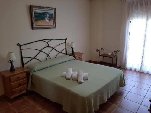 a bedroom with a bed with two towels on it at Casa Herron in Cazorla