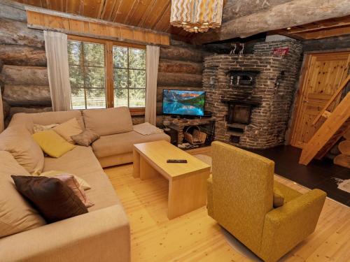 a living room with a couch and a stone fireplace at Holiday Home Villa vuosselinjärvi by Interhome in Ruka