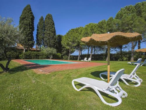 two chairs and an umbrella next to a swimming pool at Apartment Camiglia by Interhome in Tavarnelle Val di Pesa