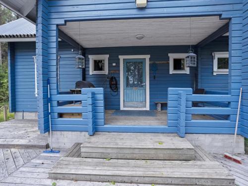 una casa azul con puerta azul y porche en Holiday Home Kivelä by Interhome, en Haukiniemi