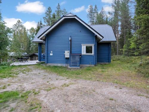 una casa azul en medio de un campo en Holiday Home Kivelä by Interhome, en Haukiniemi