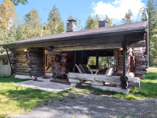 eine Blockhütte mit einer Veranda und Stühlen in der Unterkunft Holiday Home Hallan kelo by Interhome in Ruka