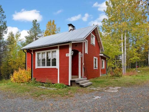 ein rotes Haus mit einem Hund drauf. in der Unterkunft Holiday Home Vuorimäki by Interhome in Ruka