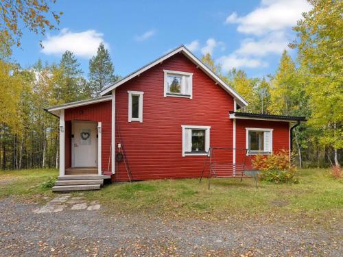 ein rotes Haus mit einer weißen Tür im Hof in der Unterkunft Holiday Home Vuorimäki by Interhome in Ruka