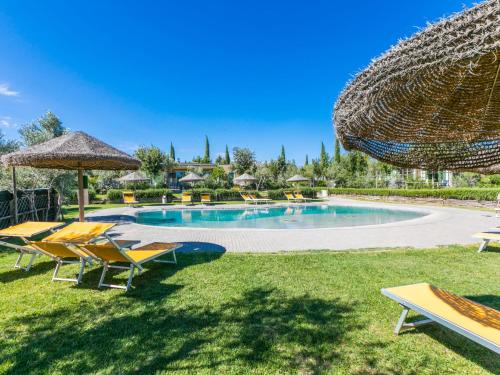 una piscina con sedie a sdraio e ombrelloni di Holiday Home Di Toscana Holidays by Interhome a Collemezzano