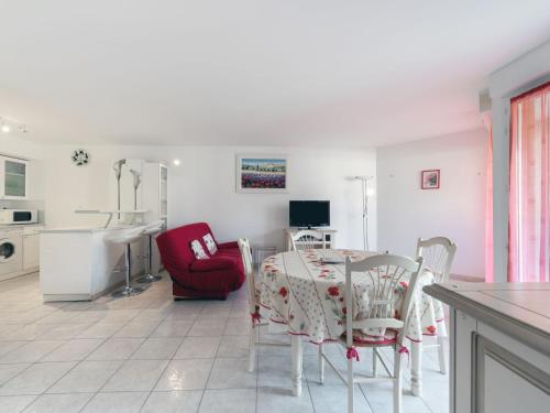 a dining room with a table and a red chair at Apartment Côté Port by Interhome in Cavalaire-sur-Mer