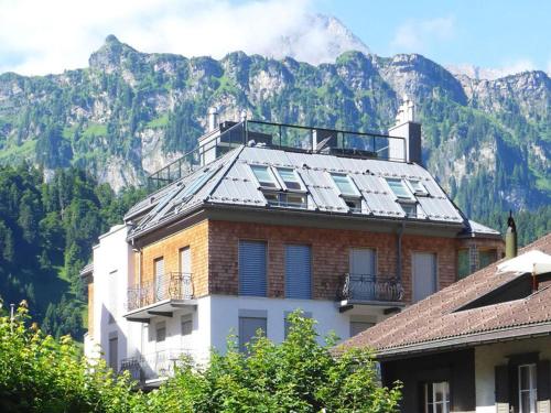 ein Gebäude mit einem Berg im Hintergrund in der Unterkunft Apartment Villa Maria 33 by Interhome in Engelberg
