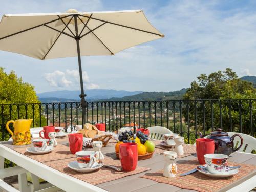 a table with an umbrella and a table with food at Holiday Home De Ferreira by Interhome in Ponte de Lima