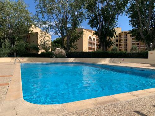 une grande piscine bleue devant un immeuble dans l'établissement Apartment Le Lagon Bleu-3 by Interhome, au Cap d'Agde