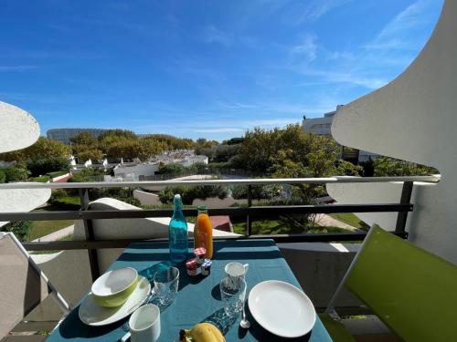 une table bleue avec des assiettes et des verres sur un balcon dans l'établissement Apartment Du Soleil-4 by Interhome, à La Grande Motte