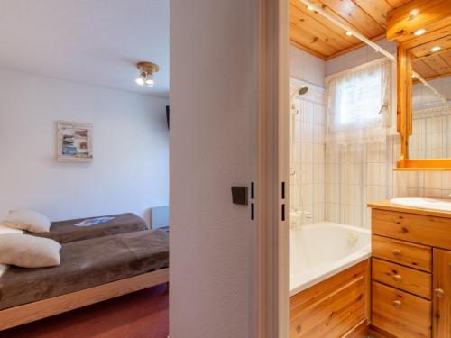 ティーニュにあるApartment Les Tommeuses - Val Claret-30 by Interhomeのベッドルーム1室(ベッド1台付)、バスルーム(バスタブ付)