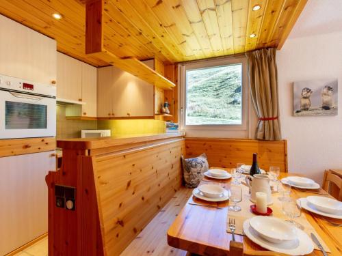 une cuisine avec une table en bois et des plaques de cuisson. dans l'établissement Apartment Les Tommeuses - Val Claret-30 by Interhome, à Tignes
