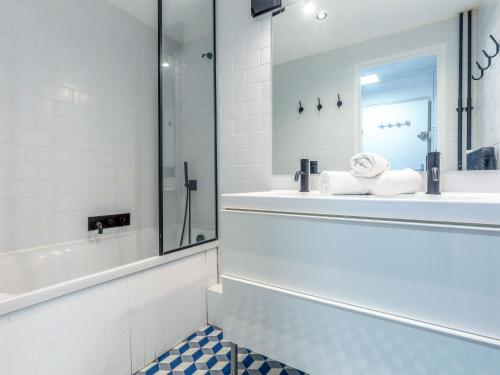 une salle de bain avec une baignoire, un lavabo et un miroir dans l'établissement Apartment Le Pramecou - Val Claret-14 by Interhome, à Tignes