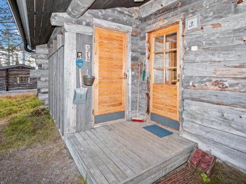 ルカにあるHoliday Home Karhunpesä by Interhomeの木製のドアとポーチ付きのキャビン
