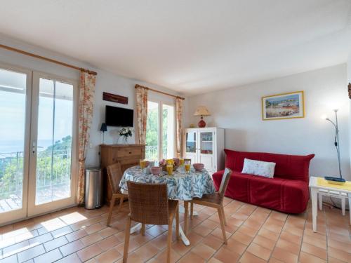 a living room with a table and a red couch at Apartment Les Sauvagières II-1 by Interhome in Cavalaire-sur-Mer