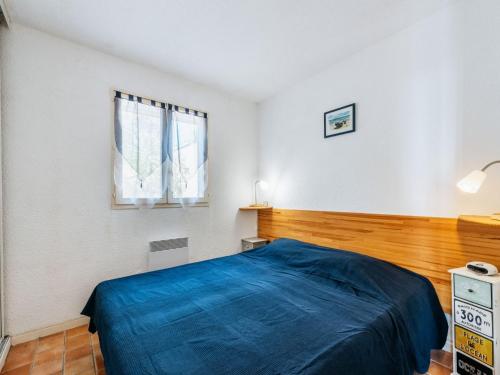 une chambre avec un lit bleu et une fenêtre dans l'établissement Apartment Les Sauvagières II-1 by Interhome, à Cavalaire-sur-Mer