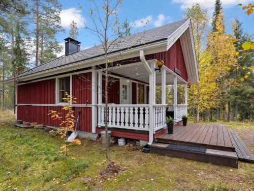 une maison rouge avec une terrasse couverte et une terrasse dans l'établissement Holiday Home Kaukosaaren ahonrinne by Interhome, à Ruka