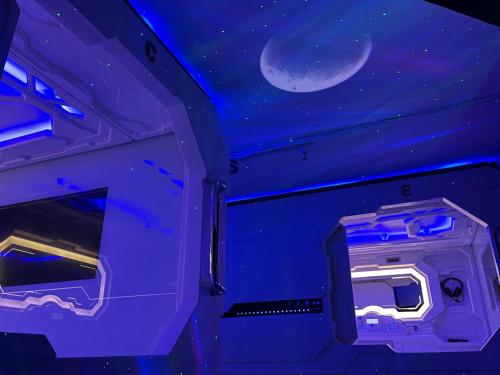 Cette chambre est dotée d'un plafond violet avec une lune en croissant. dans l'établissement BMAX SPACEPODS, à Pusok