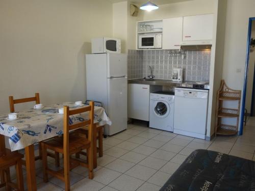 une cuisine avec une table et un réfrigérateur blanc dans l'établissement Apartment Le Clos de St Cyprien-10 by Interhome, à Saint-Cyprien