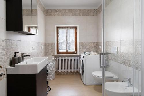 La salle de bains blanche est pourvue d'un lavabo et de toilettes. dans l'établissement Casa de Lorenzo, à Vodo Cadore