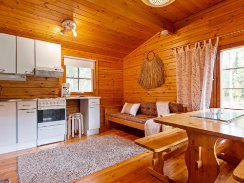 Cabaña de madera con cocina y sala de estar. en Holiday Home Koskimökki by Interhome, en Kortteinen