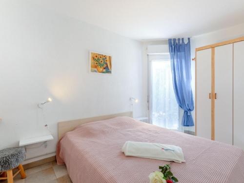 een witte slaapkamer met een bed en een raam bij Apartment Les Mas de la Mer-2 by Interhome in Saint-Aygulf