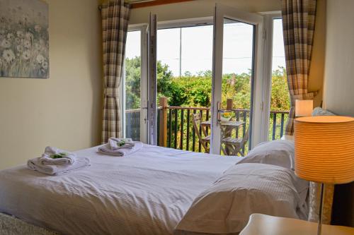 a bedroom with a bed and a balcony at The Fairways in Portpatrick