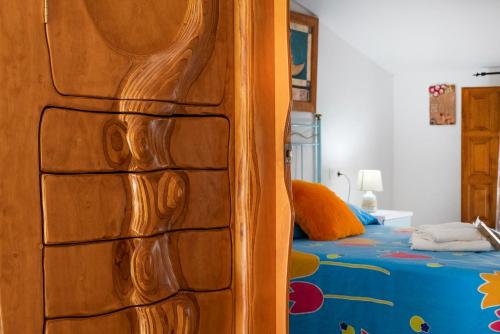 Una puerta de madera en un dormitorio con cama en Encantadora casa de pueblo para 7 pax con gran Terraza, en Jimera de Líbar