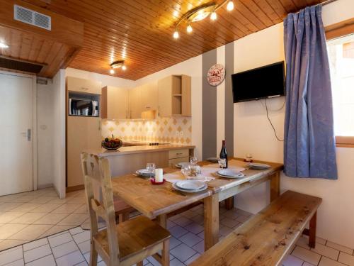 Apartment Super Tignes-2 by Interhome في تينيِ: مطبخ مع طاولة خشبية وغرفة طعام