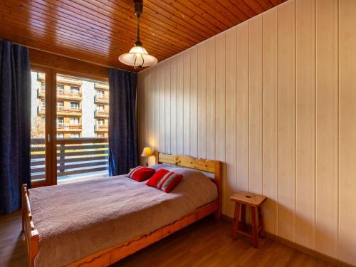 une chambre avec un lit avec des oreillers rouges et une fenêtre dans l'établissement Apartment Super Tignes-2 by Interhome, à Tignes